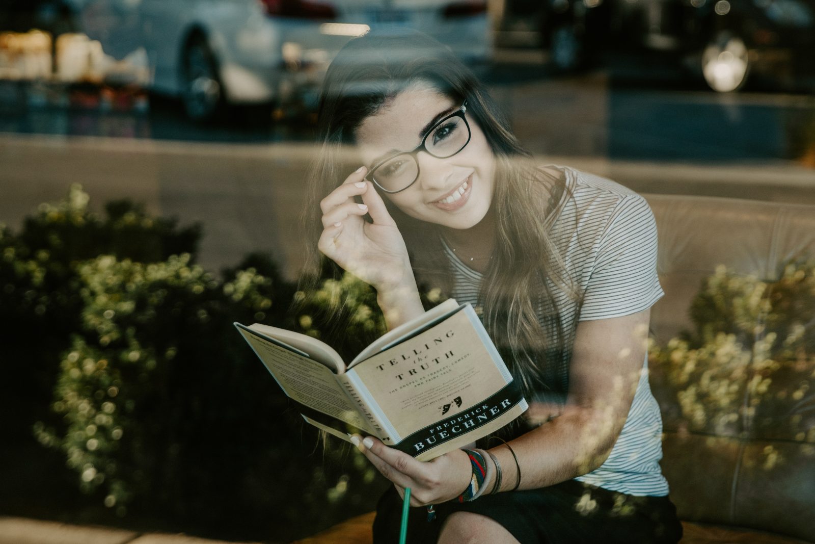 窓際で本を読む眼鏡をかけた女性